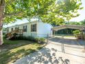 A view of the house and the covered parking area, enclosed by a chain link fence at 36812 Skycrest Blvd, Fruitland Park, FL 34731