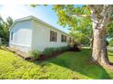 A view of the side of the house with a landscaped flower bed and grassy yard at 36812 Skycrest Blvd, Fruitland Park, FL 34731