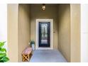 Inviting front entrance with a decorative glass door, covered porch, and a cozy bench at 418 Rock Springs Cir, Groveland, FL 34736