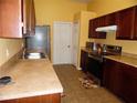 Well-lit eat-in kitchen with wood cabinets and tile flooring at 5016 Mcdonald Rd, Zellwood, FL 32798