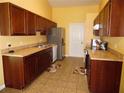 Traditional kitchen with wood cabinets, a stainless steel fridge, and tile flooring at 5016 Mcdonald Rd, Zellwood, FL 32798
