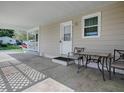 Covered carport showing a seating area and a white front door at 601 Jason Dr, The Villages, FL 32159