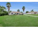 Attractive single-story home featuring large front lawn, tidy landscaping, and tall palm trees at 6640 Sw 85Th Pl, Ocala, FL 34476