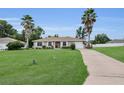Lovely home boasts a verdant lawn, tidy landscaping, and tall palm trees for added curb appeal at 6640 Sw 85Th Pl, Ocala, FL 34476