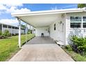 Covered carport featuring a clean concrete floor, adjacent to the home's entrance at 717 W Coach N Four Dr, Leesburg, FL 34748