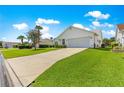 Single-story home with a two-car garage, manicured lawn, and well-maintained landscaping on a sunny day at 804 Santa Rita Way, Lady Lake, FL 32159