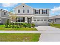 Inviting two-story home featuring a manicured front lawn and a two-car garage at 872 Griffon Ave, Lake Alfred, FL 33850