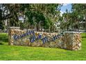 Stone entrance sign for Country Club Manor adds charm to the serene neighborhood setting at 10 Cocos Plumosa Dr, Eustis, FL 32726