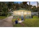 Single-story home with screen porch, carport, and decorative landscaping creating a welcoming curb appeal at 10 Cocos Plumosa Dr, Eustis, FL 32726