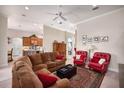 Spacious living room with a cozy sectional, red armchairs, and view to the kitchen at 1043 Juliette Blvd, Mount Dora, FL 32757