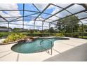 Inviting in-ground pool featuring a waterfall and screened-in lanai for ultimate relaxation at 1043 Juliette Blvd, Mount Dora, FL 32757