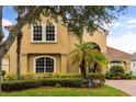 Two-story home with mature landscaping, arched entryway, and brick driveway at 1444 Whitney Isles Dr, Windermere, FL 34786