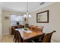 Traditional dining room featuring a large wooden table with seating for eight and a decorative chandelier at 1702 Hoofprint Ct, Fruitland Park, FL 34731