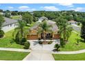 Aerial view of a well-maintained home, lush lawns and mature palms in a serene neighborhood at 1892 Sanderling Dr, Clermont, FL 34711