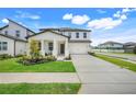 Charming two-story home with a well-manicured lawn, a two-car garage and inviting front porch at 2161 Gold Dust Dr, Minneola, FL 34715