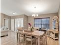 Airy dining room featuring a light-toned wood table and a contemporary chandelier at 25400 Waterbrook Ct, Leesburg, FL 34748