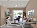 Cozy living room featuring neutral decor, vaulted ceilings, and sliding glass doors to the patio at 25400 Waterbrook Ct, Leesburg, FL 34748