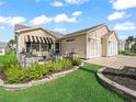 Charming home with a front porch, stone pillars, manicured landscaping, and an attached two-car garage at 2620 Persimmon Loop, The Villages, FL 32162