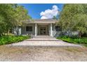 Charming home featuring a stone pathway leading to a covered front porch with classic columns at 32511 County Road 437, Sorrento, FL 32776