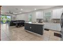 Bright and modern kitchen featuring white cabinets, stainless steel appliances, and a large island with seating at 3467 Buoy Cir, Winter Garden, FL 34787