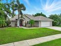 Charming single-story home with well-manicured lawn, mature trees, and a two-car garage at 4401 Abaco Dr, Tavares, FL 32778