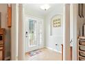 Inviting foyer featuring tile flooring, white columns, and a decorative glass front door at 4401 Abaco Dr, Tavares, FL 32778