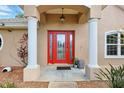 Home featuring a red front door framed by classic white columns on an inviting porch at 4401 Abaco Dr, Tavares, FL 32778