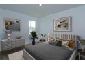 Cozy bedroom with neutral tones, a comfortable bed, decorative pillows, and natural light from a window at 5002 Abigail Dr, Lake Wales, FL 33859