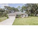 Attractive single-story home featuring a two-car garage and a well-kept lawn at 5005 County Road 125B1, Wildwood, FL 34785