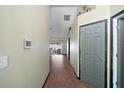 Hallway featuring tile floors, textured walls, a utility closet, and a smart home control panel at 6001 Pine Bluff Ln, Mascotte, FL 34753
