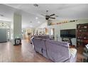 Open-concept living room featuring a large sectional sofa, modern ceiling fan, and tile flooring throughout at 6001 Pine Bluff Ln, Mascotte, FL 34753