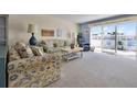 Cozy living room with plush seating, neutral carpeting, and a sunny balcony with outdoor chairs at 601 N Mcdonald St # 2, Mount Dora, FL 32757