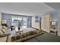 Bright living room with a wall-mounted TV, a Murphy bed, and access to a balcony at 601 N Mcdonald St # 2, Mount Dora, FL 32757