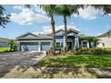 Beautiful two-story home featuring a three-car garage, well-manicured lawn, and mature palm trees at 6048 Tremayne Dr, Mount Dora, FL 32757