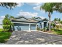Charming two-story home with a three-car garage, brick-paved driveway and tropical landscaping at 6048 Tremayne Dr, Mount Dora, FL 32757