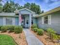 Inviting front porch with seating, lovely landscaping, and beautiful light blue siding at 627 Timbercrest Dr, Leesburg, FL 34748