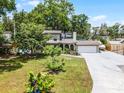 Charming two-story home featuring mature trees, landscaped yard, and long driveway at 628 Drew Ave, Clermont, FL 34711