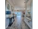 Inviting hallway with wood-look flooring, stylish console table, and views into the living areas at 6295 Danielson Loop, The Villages, FL 32163