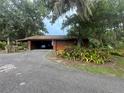Charming home featuring an open carport, mature landscaping, and a convenient circular driveway at 6616 Tuscawilla Dr, Leesburg, FL 34748