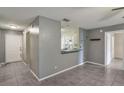 Cozy living room featuring gray walls, tiled floors, and a breakfast bar viewing the kitchen at 8634 Garden Way Rd, Groveland, FL 34736