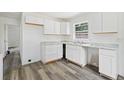 Bright kitchen with white cabinets, stylish countertops, and wood-look flooring at 1134 Cr 464, Lake Panasoffkee, FL 33538