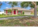 Charming single-story home featuring a red front door, red shutters, and well-manicured landscaping at 1216 Cheshire St, Groveland, FL 34736