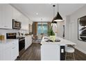 Modern kitchen with white cabinets, stainless steel appliances, island with bar seating, and adjacent dining area at 13108 Serene Glade Rd, Winter Garden, FL 34787