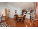 Open dining area featuring hardwood floors, chandelier lighting, and views of the kitchen at 1654 Blossom Ter, The Villages, FL 32162