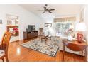 Inviting living room with hardwood floors, a ceiling fan, and sliding glass doors to a patio at 1654 Blossom Ter, The Villages, FL 32162