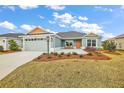 Charming single-story home featuring manicured landscaping and a welcoming front porch with seating at 2055 Merideth Ter, The Villages, FL 34762