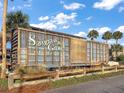 Rustic Sawgrass Grove train car attraction with palm trees set against a bright blue sky at 2055 Merideth Ter, The Villages, FL 34762