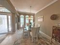 Elegant dining room featuring a glass table, modern chandelier, and natural light from arched windows at 2299 Twickingham Ct, Clermont, FL 34711