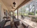 Inviting screened patio with comfortable seating, ceiling fans, and outdoor bar area, perfect for entertaining at 2299 Twickingham Ct, Clermont, FL 34711