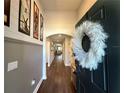 Inviting entryway with wood-look floors, neutral paint, and a decorative wreath on the black front door at 295 Whirlaway Drive, Davenport, FL 33837